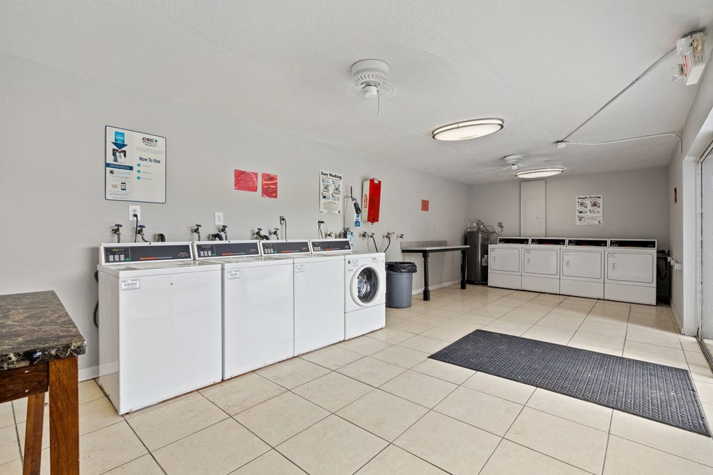 a kitchen with white appliances and counters and a washer and dryer