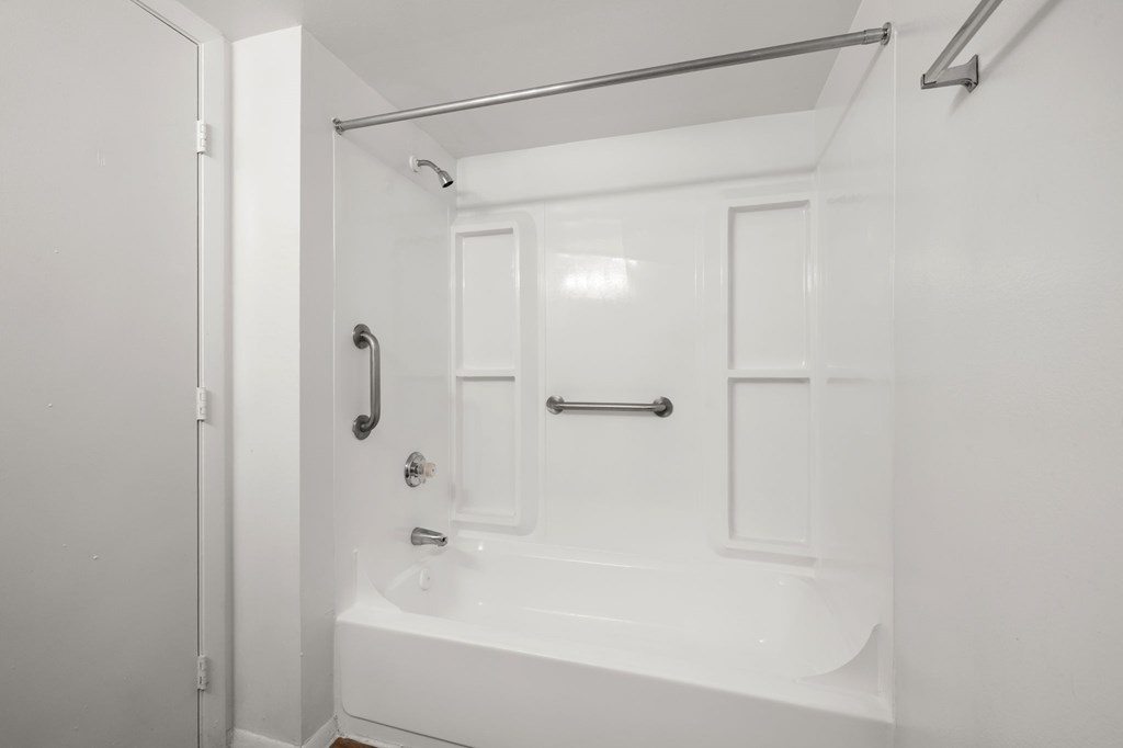 A white bathroom with a tub and shower.