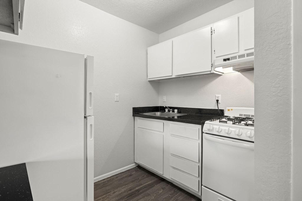 A kitchen with white appliances and cabinets.