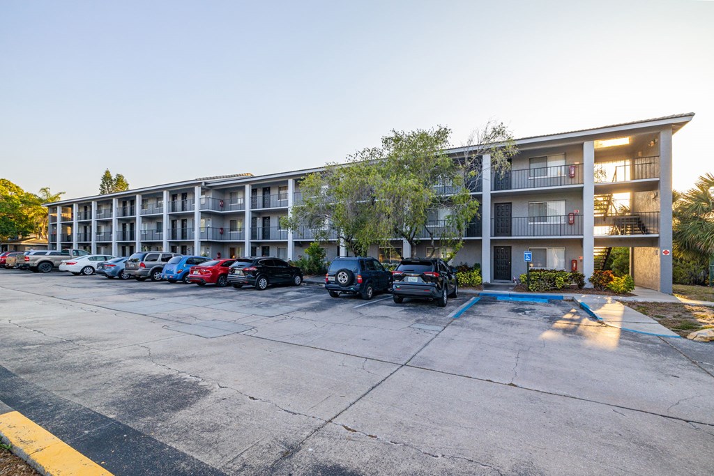 A parking lot with cars and apartment buildings in the background.