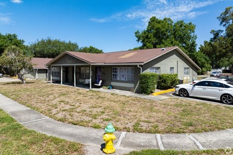 A house with a yellow fire hydrant in front of it.