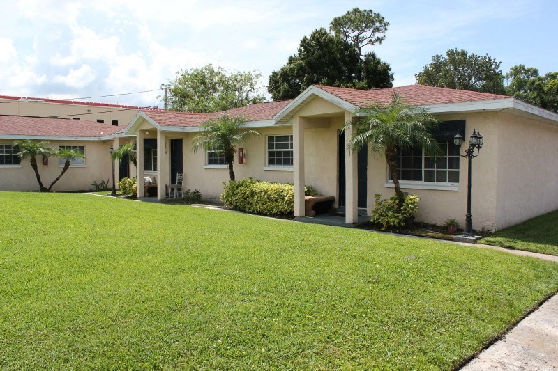 a house with a lawn and palm trees