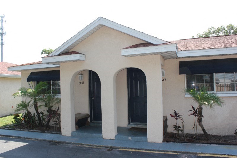 the front of a house with two doors and a porch