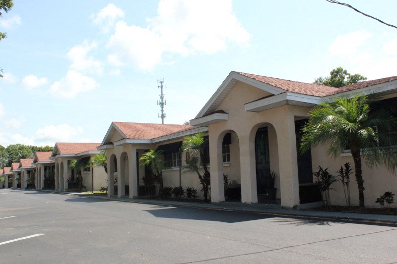 a row of houses with palm trees in front of a street