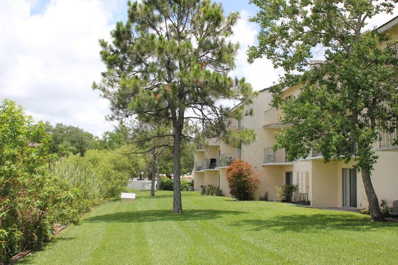 a building with a lawn and trees in front of it