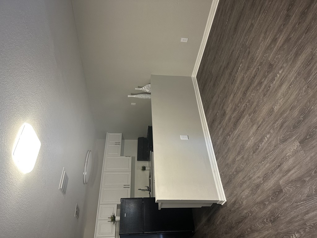 an overhead view of a kitchen with white cabinets and a wood floor