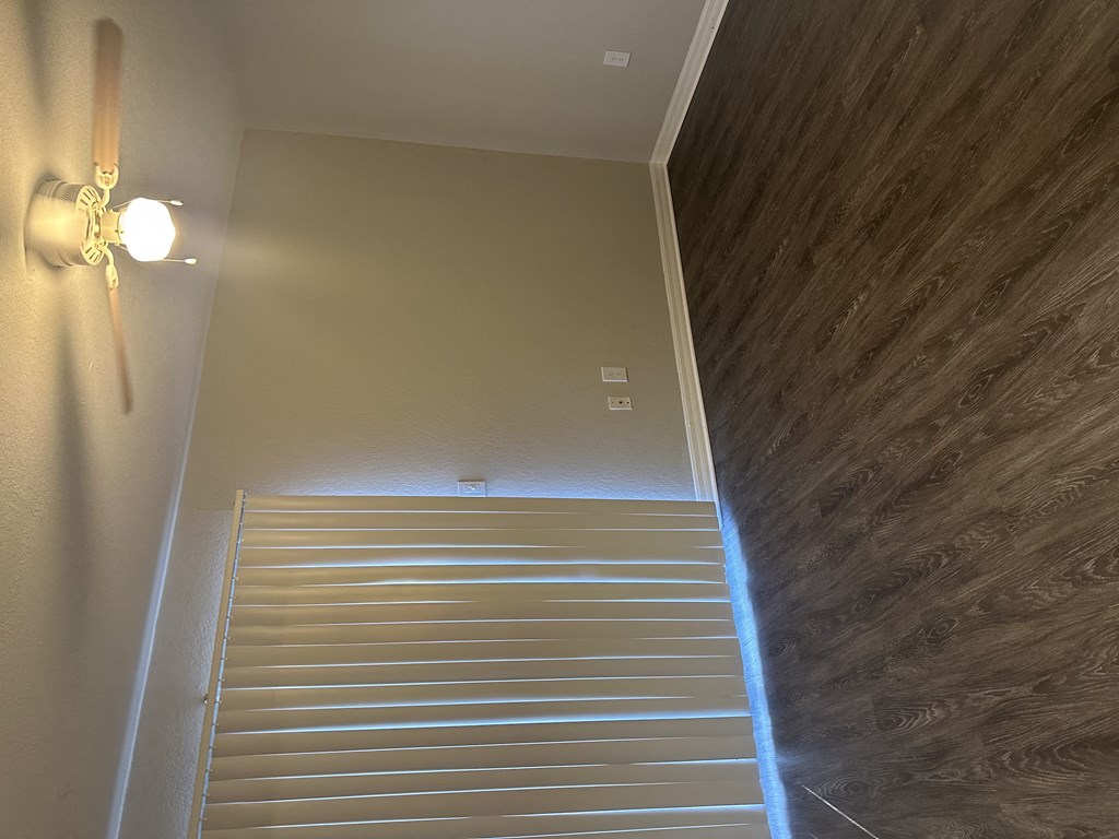 a staircase with a light on the side of it and a wall next to it