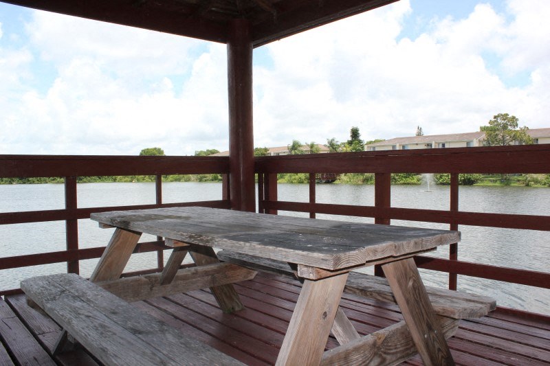 a picnic table on a deck overlooking a body of water