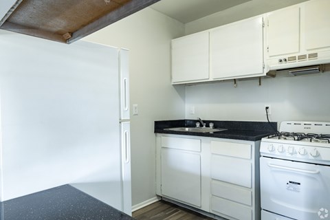 A white kitchen with a stove and cabinets.