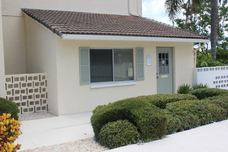 a house with a blue door and shrubs in front of it