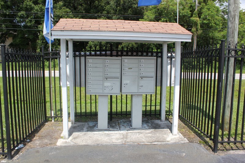 a mailbox with a gazebo in front of a fence