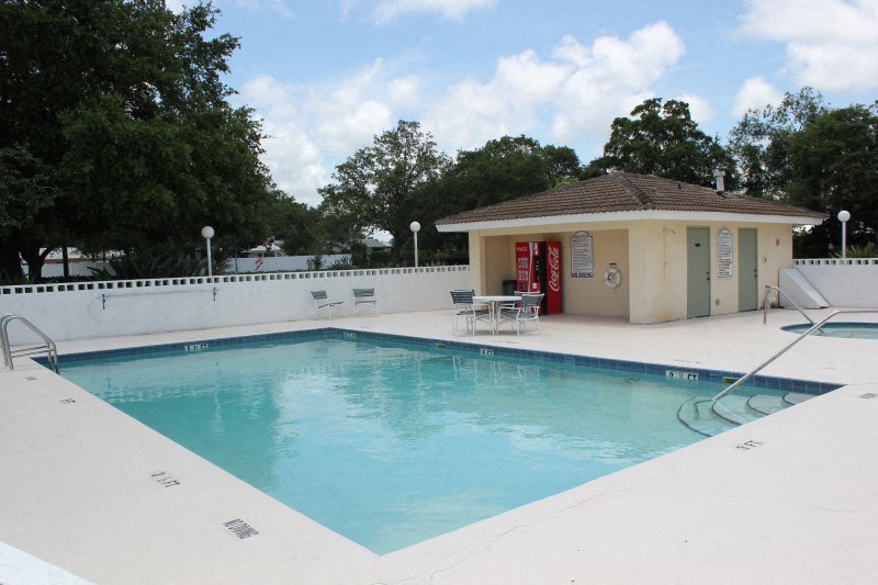 a swimming pool with a small pool house next to it
