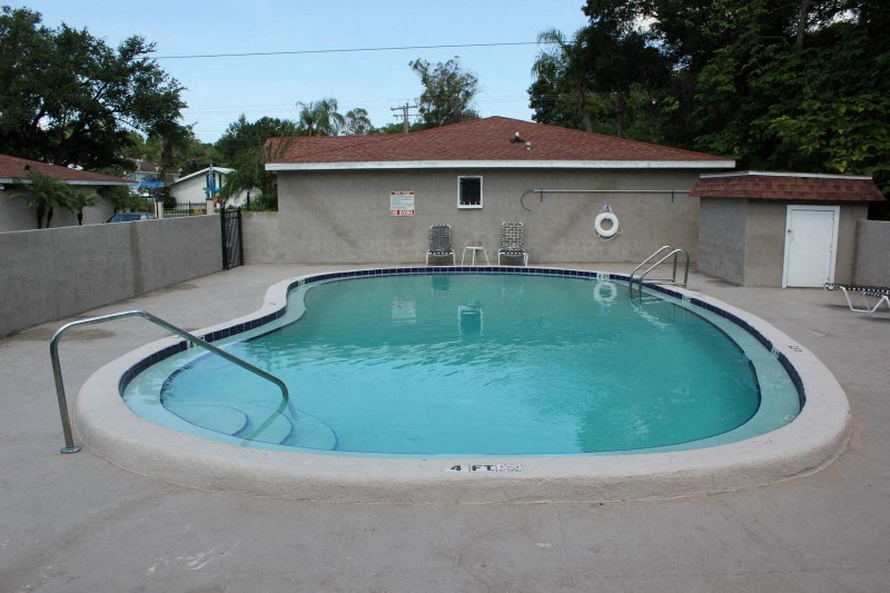 an empty pool in a backyard with a house