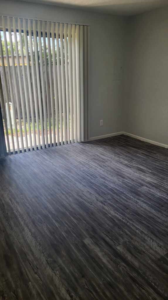 A room with a sliding door and wood flooring.