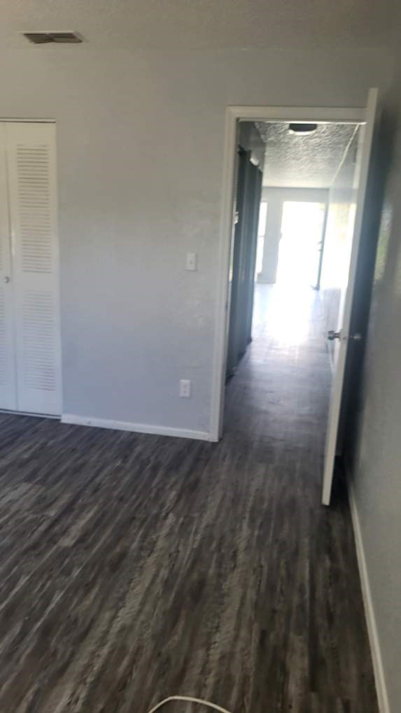 A room with a white door and a wooden floor.