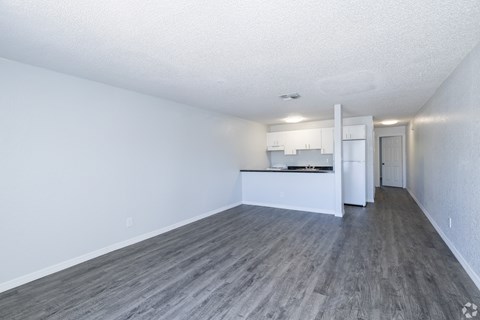 A kitchen area with white cabinets and a refrigerator.
