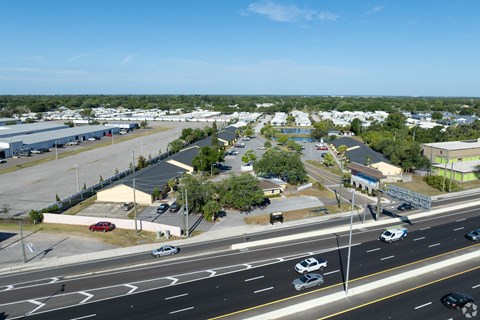 A view of a highway with cars driving on it and buildings in the background.