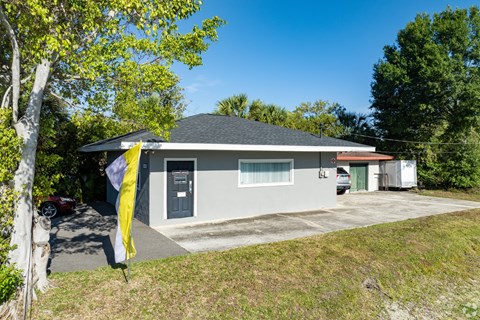A house with a grey roof and a yellow umbrella in front.