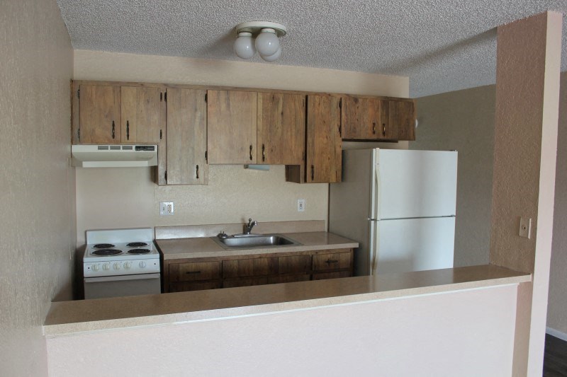 an empty kitchen with a stove refrigerator and sink