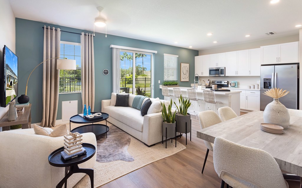 A modern living room with a white sofa and a wooden dining table.