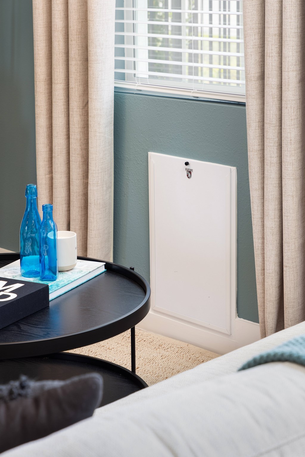 A white radiator is on a green wall next to a window.