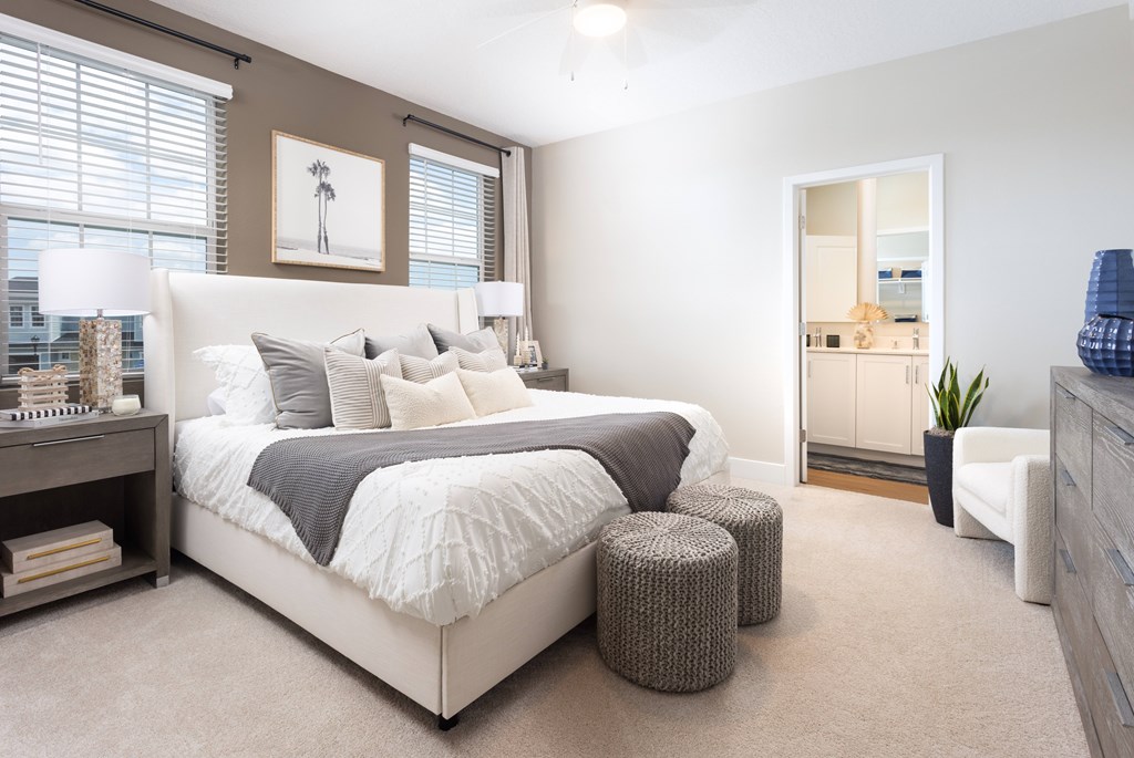 A bedroom with a large bed and a painting on the wall.
