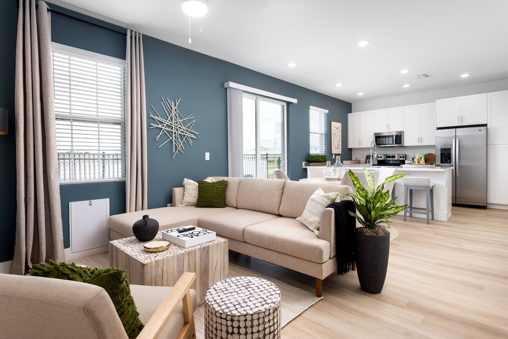 A modern living room with a beige sofa, a coffee table, and a potted plant.