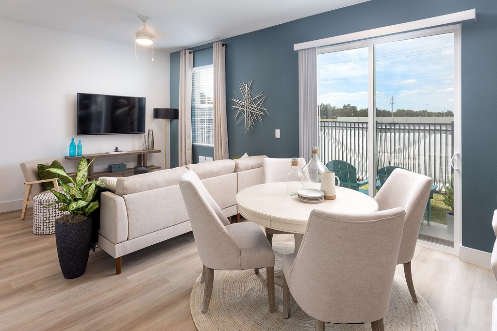 A modern living room with a white sofa set and a flat screen TV.