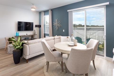 A modern living room with a white sofa set and a flat screen TV.