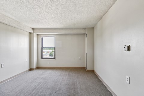A room with a carpeted floor and a window.