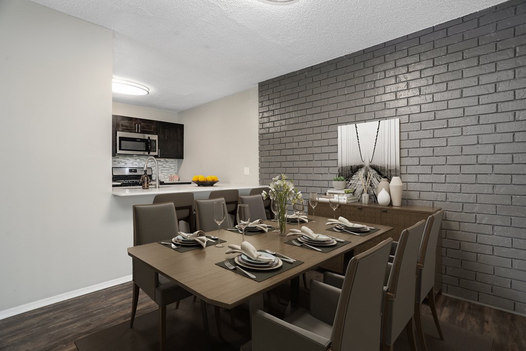 a dining room and kitchen area with a wooden table and chairs