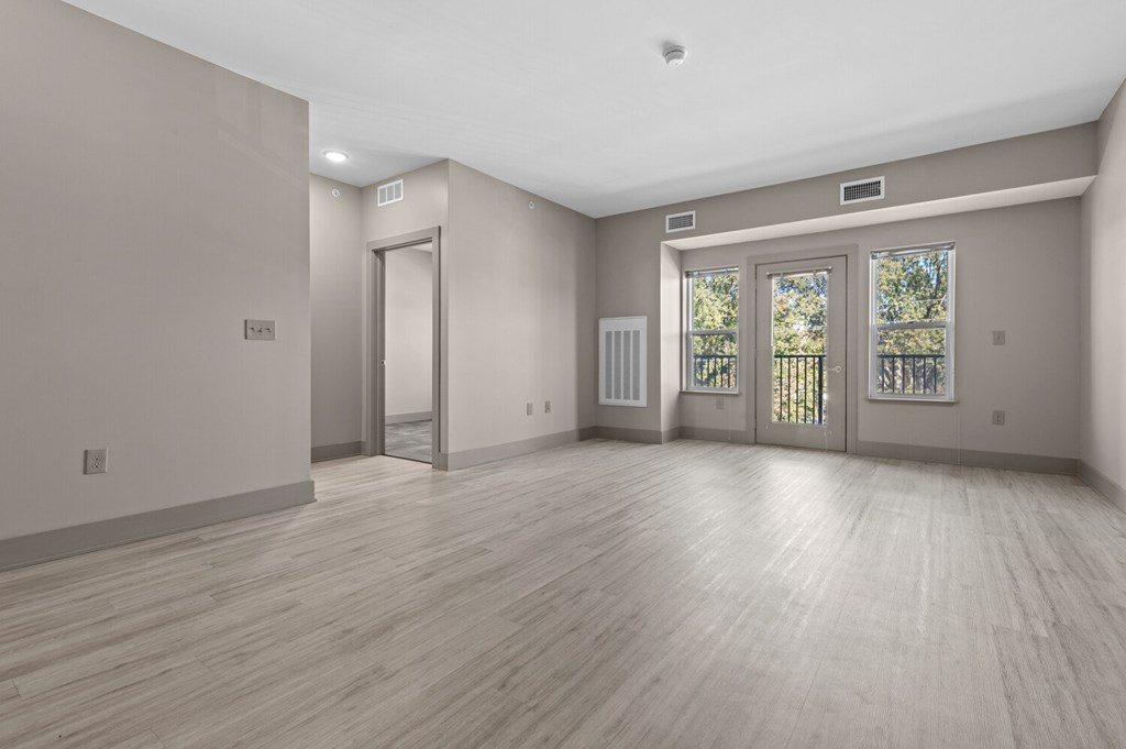 A room with wooden floors and a door leading outside.