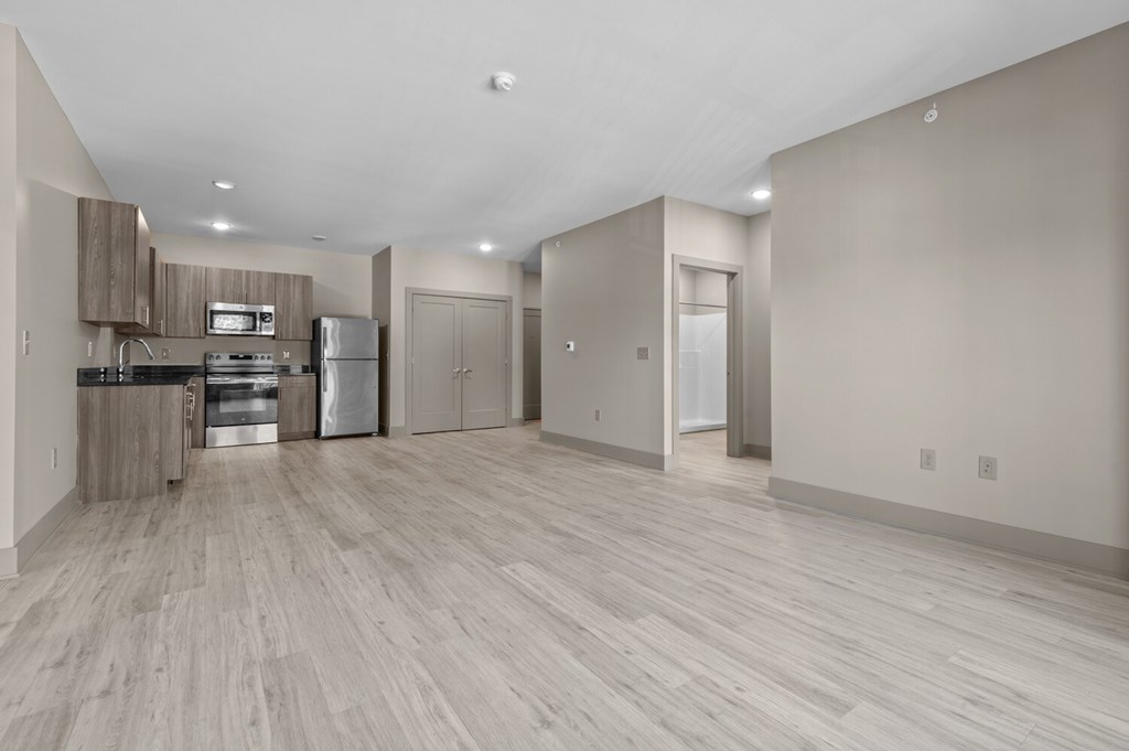 A spacious kitchen with light wood flooring and modern appliances.