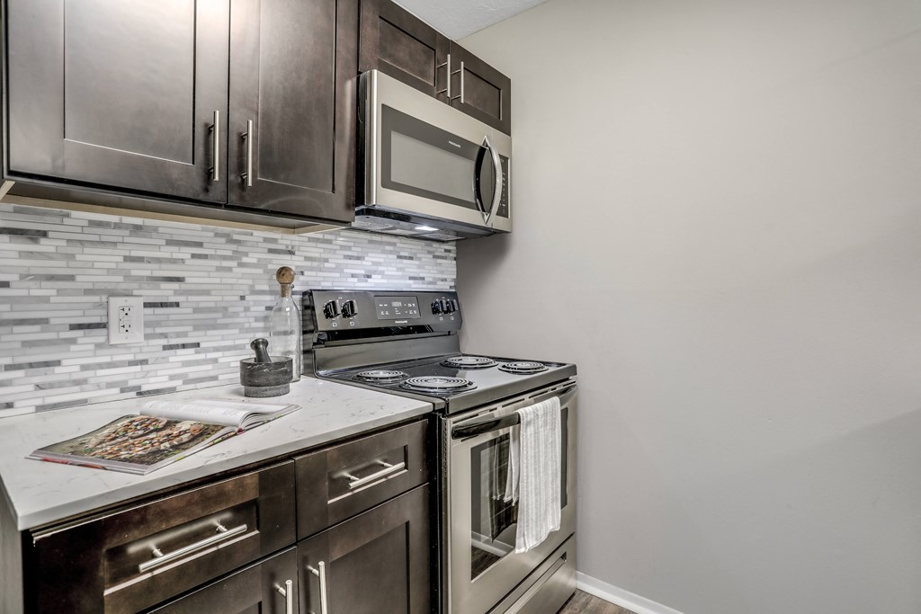 an empty kitchen with stainless steel appliances and a white counter top