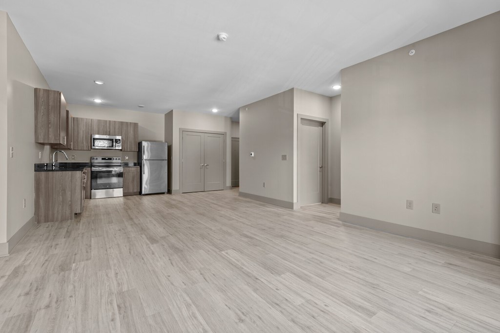 A kitchen with a refrigerator, microwave, and oven.
