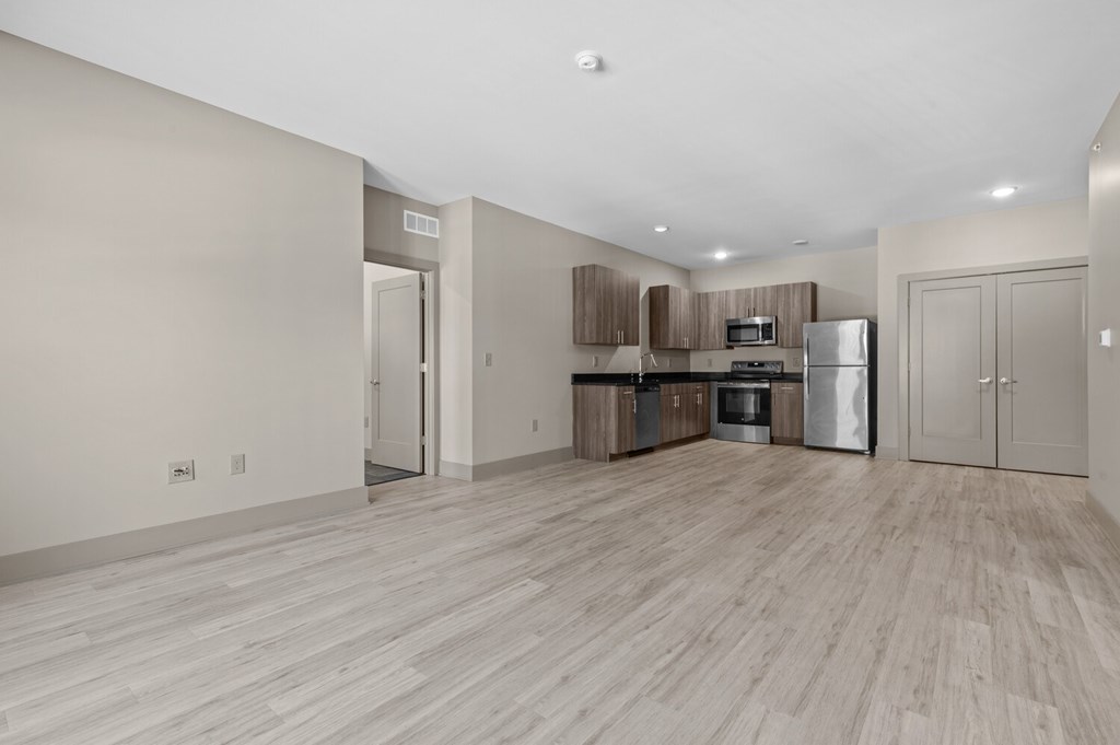 A kitchen with a refrigerator, microwave, and oven.