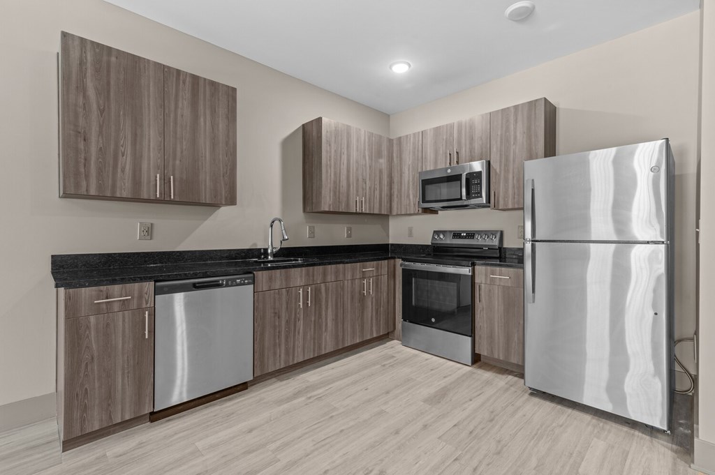 A modern kitchen with wooden cabinets and stainless steel appliances.