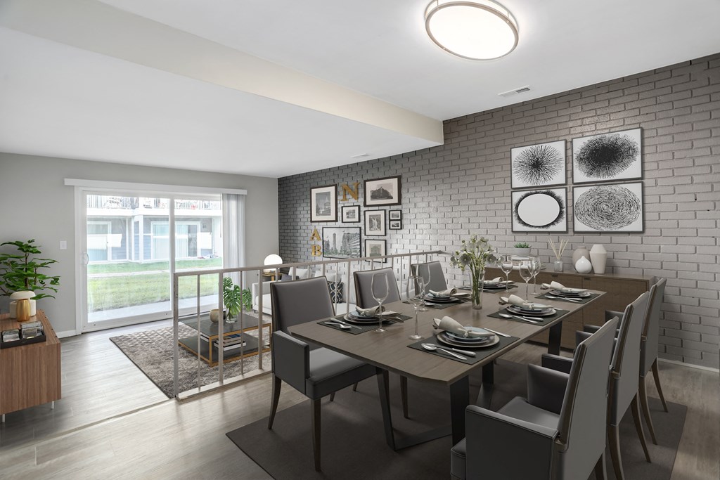 a dining room with a long table and chairs and a brick wall