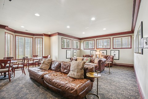 Community lounge with leather seating and dining space at Regents Club of Troy Apartments, Troy