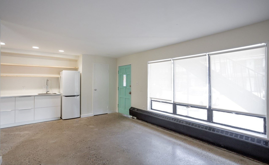 a kitchen with white cabinets and a green door