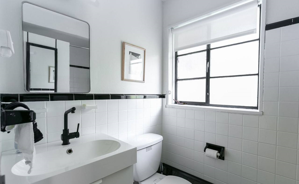 a bathroom with a toilet sink mirror and window