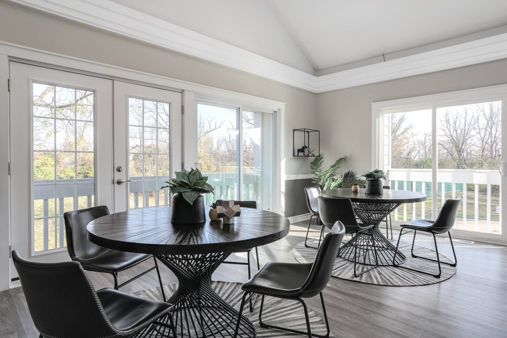 a living room with a table and chairs and a balcony