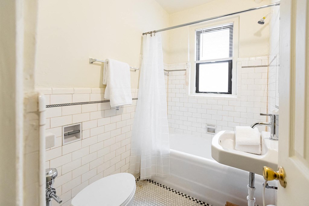 bathroom with white walls and tile and window