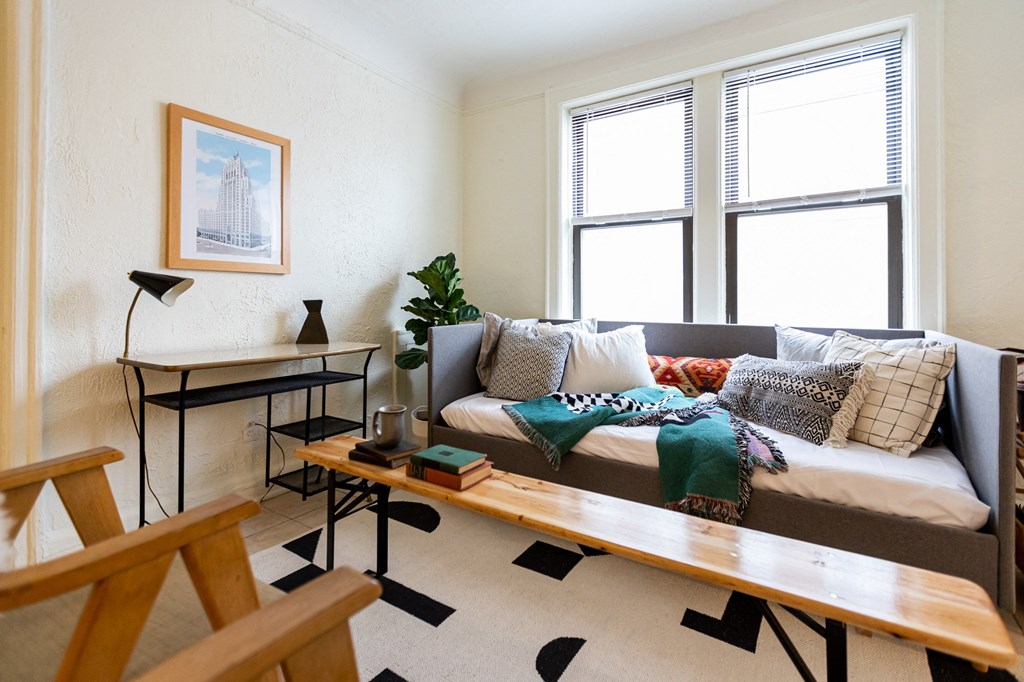 living room with blue couch and white walls and window