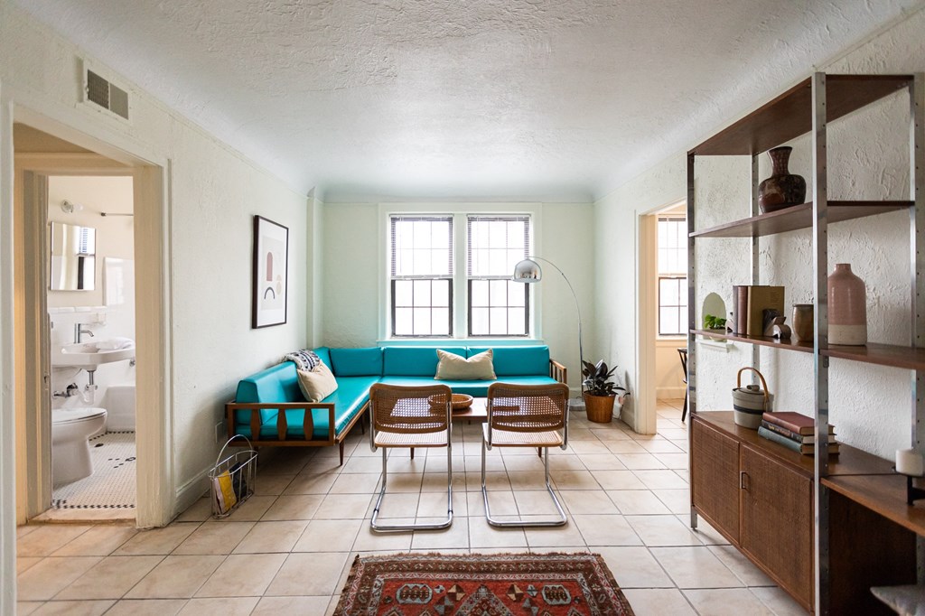 a living room with a blue couch and a table and chairs
