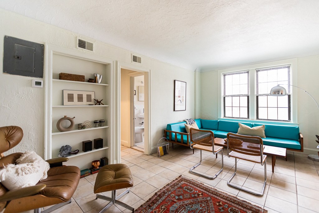 living room with blue couch and white walls and window