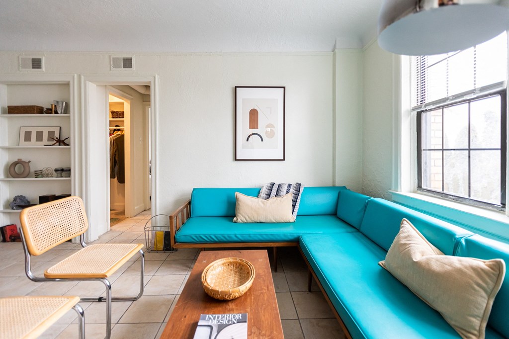 living room with blue couch and white walls and window