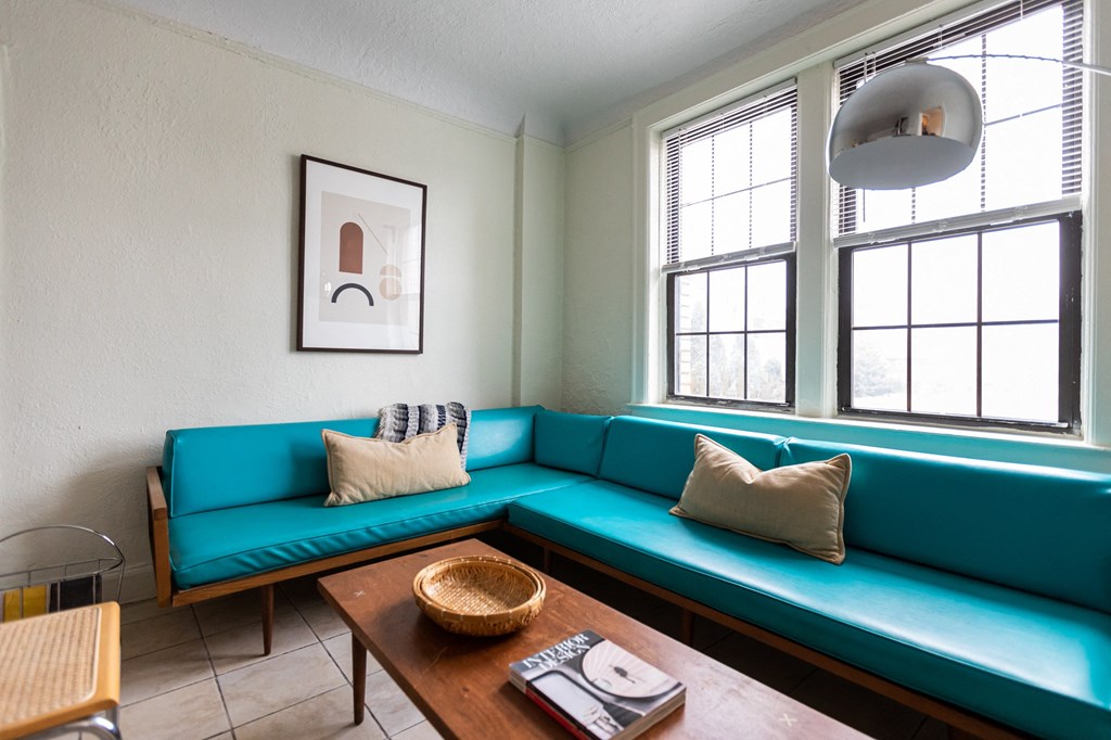 living room with blue couch and white walls and window