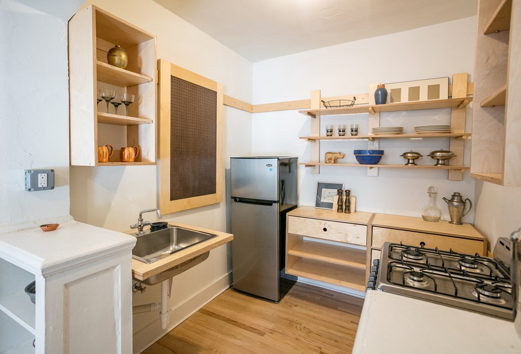 a kitchen with white cabinets and a sink and a refrigerator