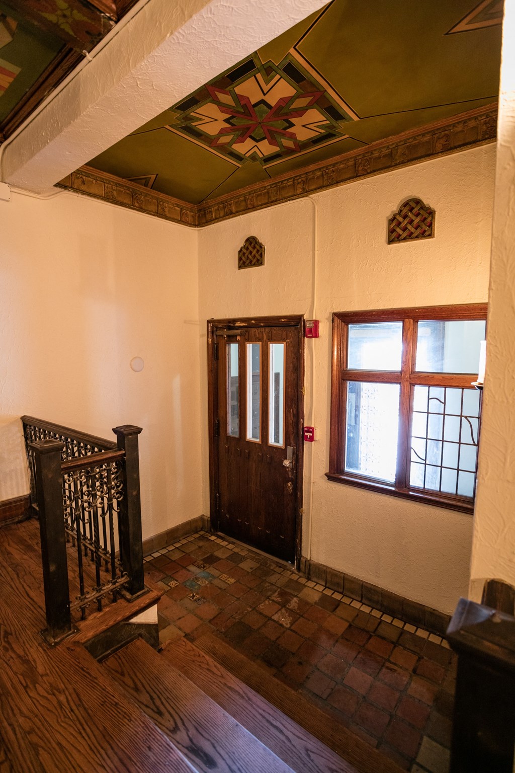 entrance to apartment building with brown door and tiled floor